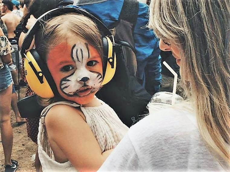 casco ruido Niña con cara pintada y con protectores acústicos puestos