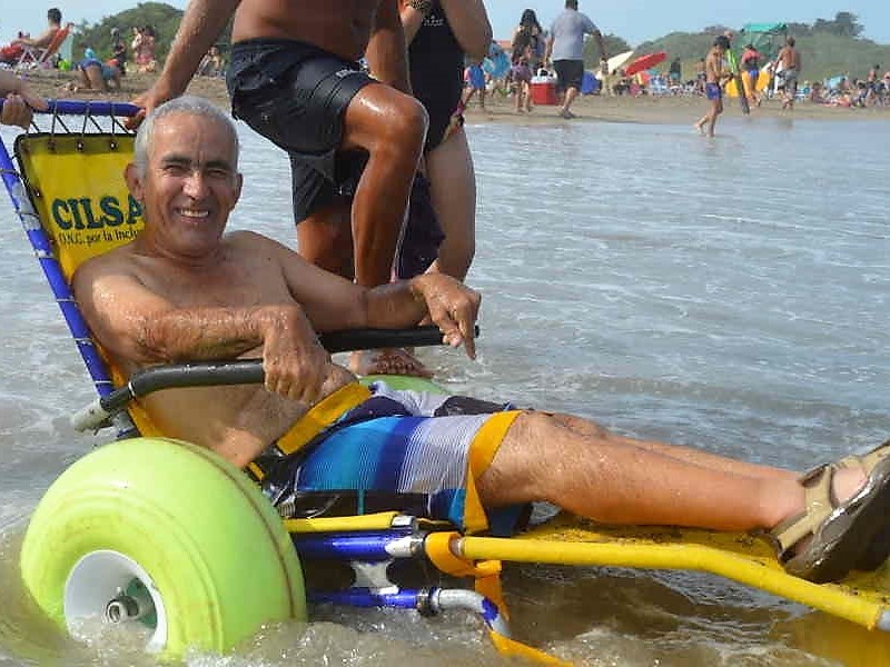 Persona mayor sonriendo en una silla de ruedas anfibia Persona mayor sonriendo en una silla de ruedas anfibia